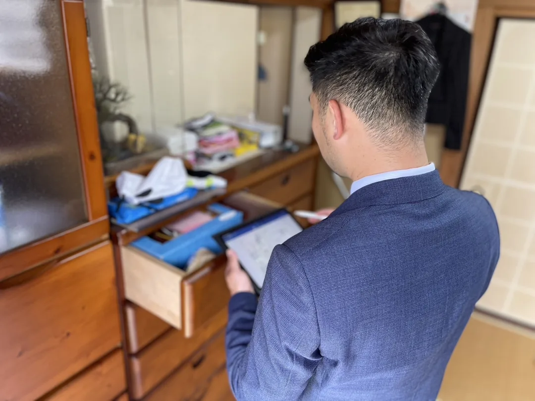 引き出しの中を確認しながら見積りを記入するスタッフ