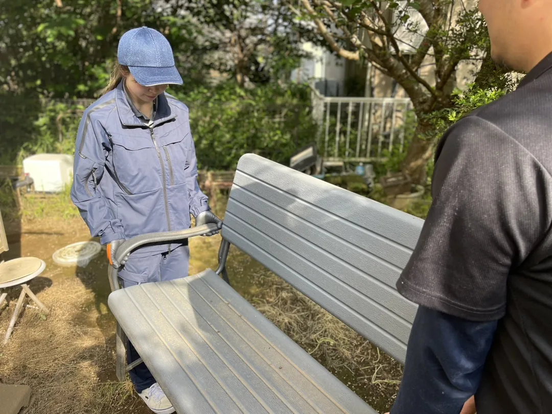 屋外の搬出経路を使って家具を運び出す作業員