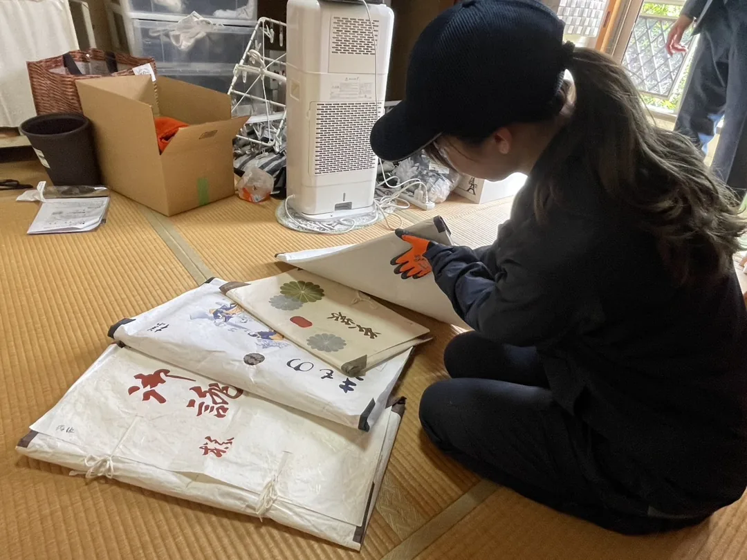 畳の部屋で品物を仕分けし箱に詰める作業の様子
